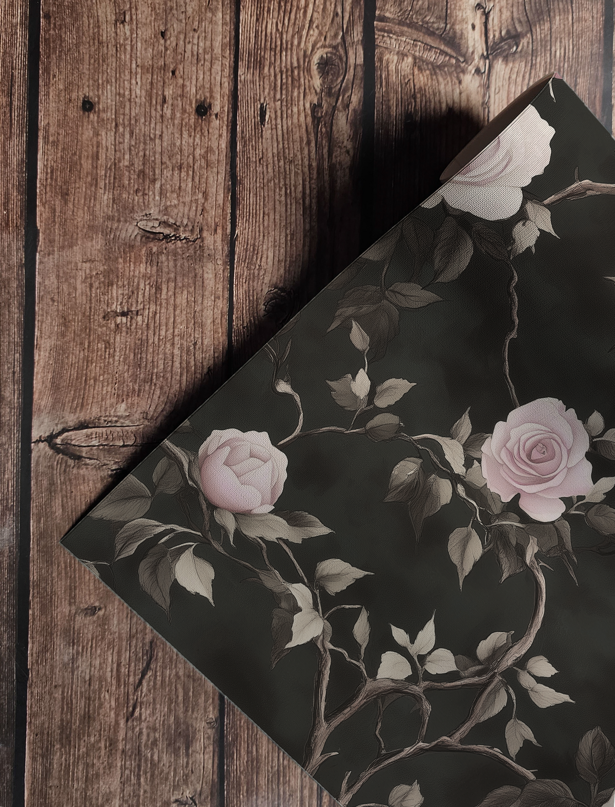 Dark floral wallpaper with ivory and blush roses climbing twisted vines on a moody black background up close