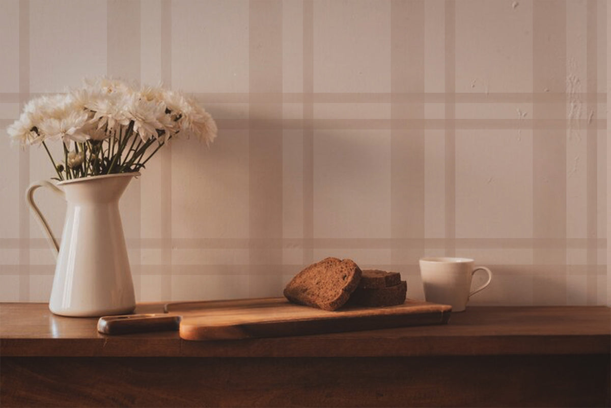 Neutral plaid wallpaper featuring soft beige and blush pink lines forming a classic tartan pattern on a warm cream background, styled in a kitchen