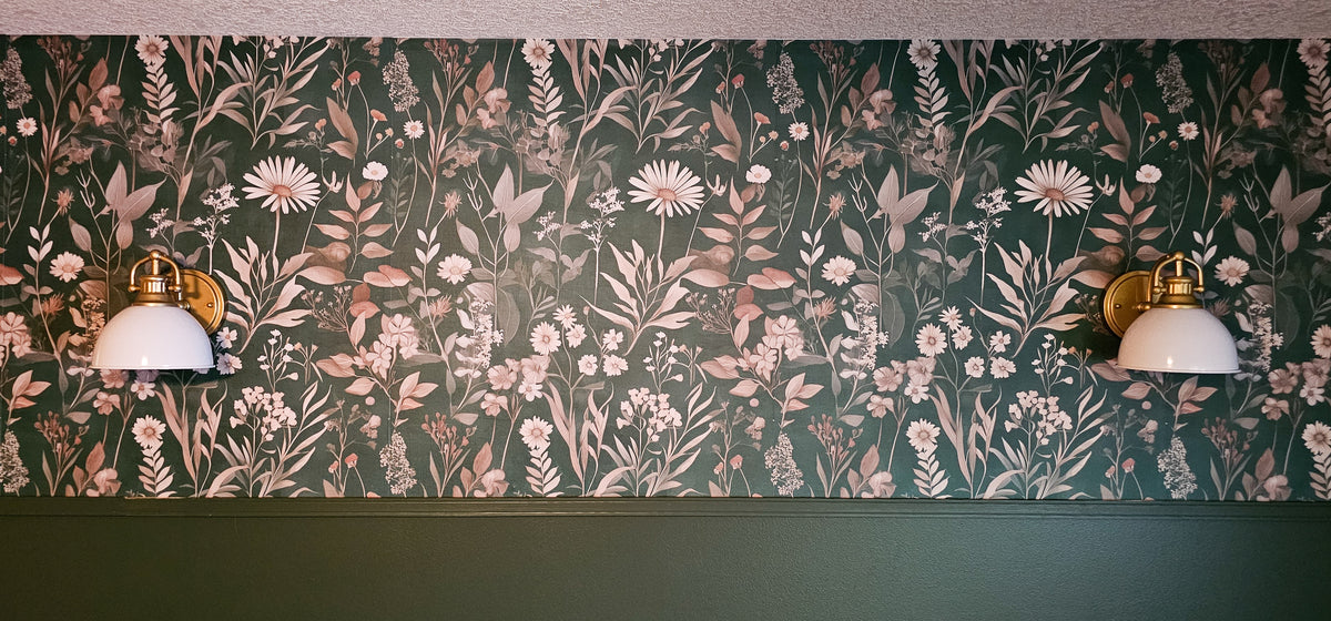 Dark moody wallpaper with dramatic oversized floral blooms in deep navy, charcoal, and inky black tones with rich botanical detail in bedroom