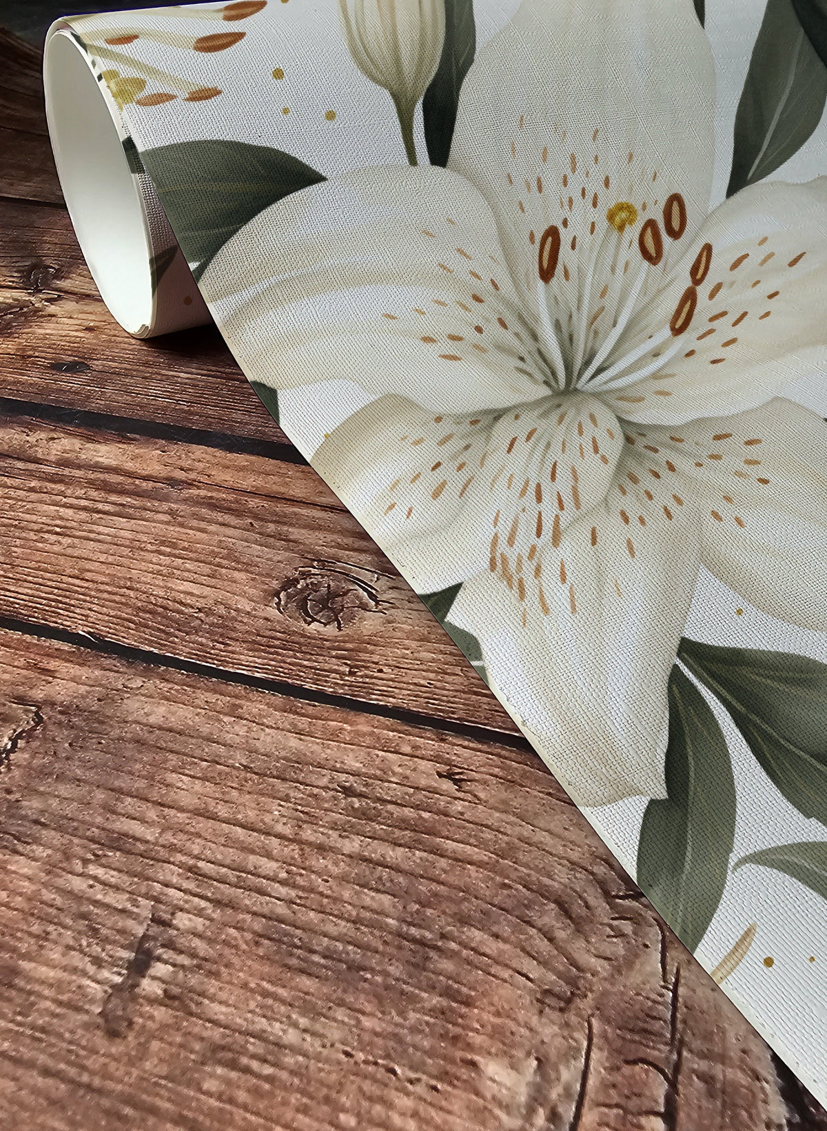 White lily floral wallpaper with large cream lilies, deep green leaves and subtle gold accents on a warm white background up close.