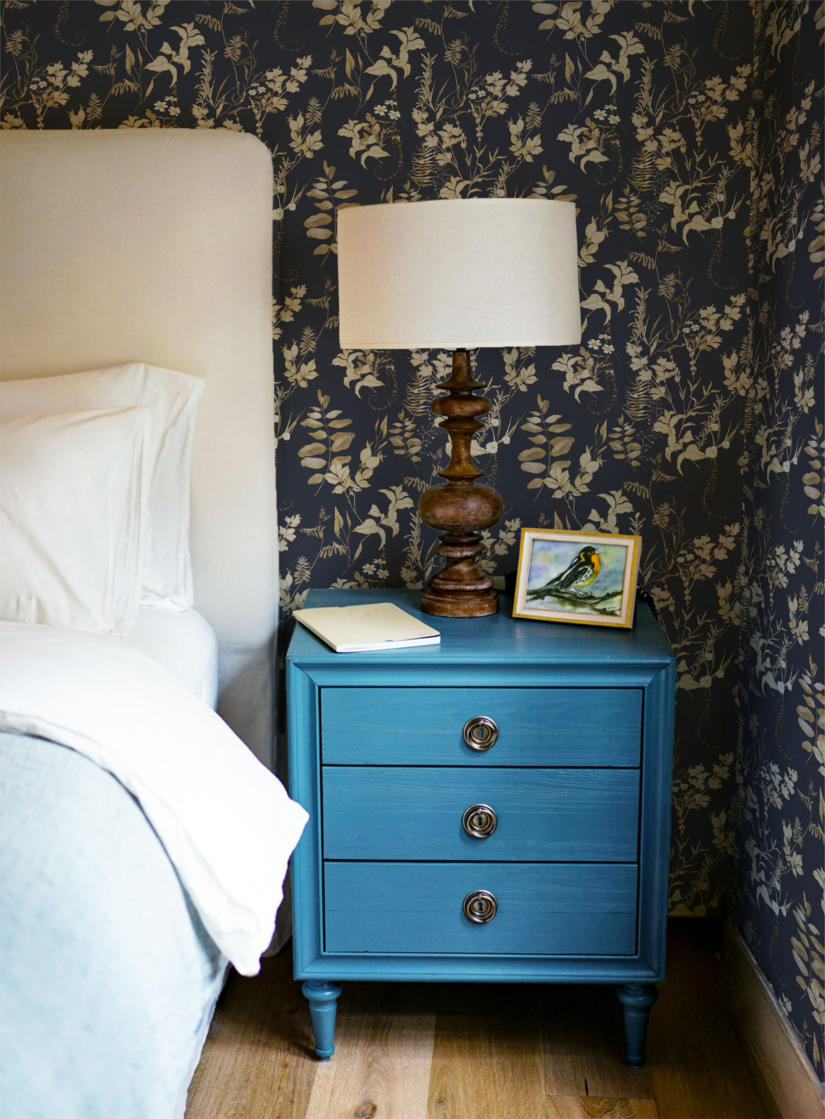 Dark floral wallpaper with vintage botanical leaves, delicate white wildflowers and warm brown foliage on a deep navy blue background in bedroom