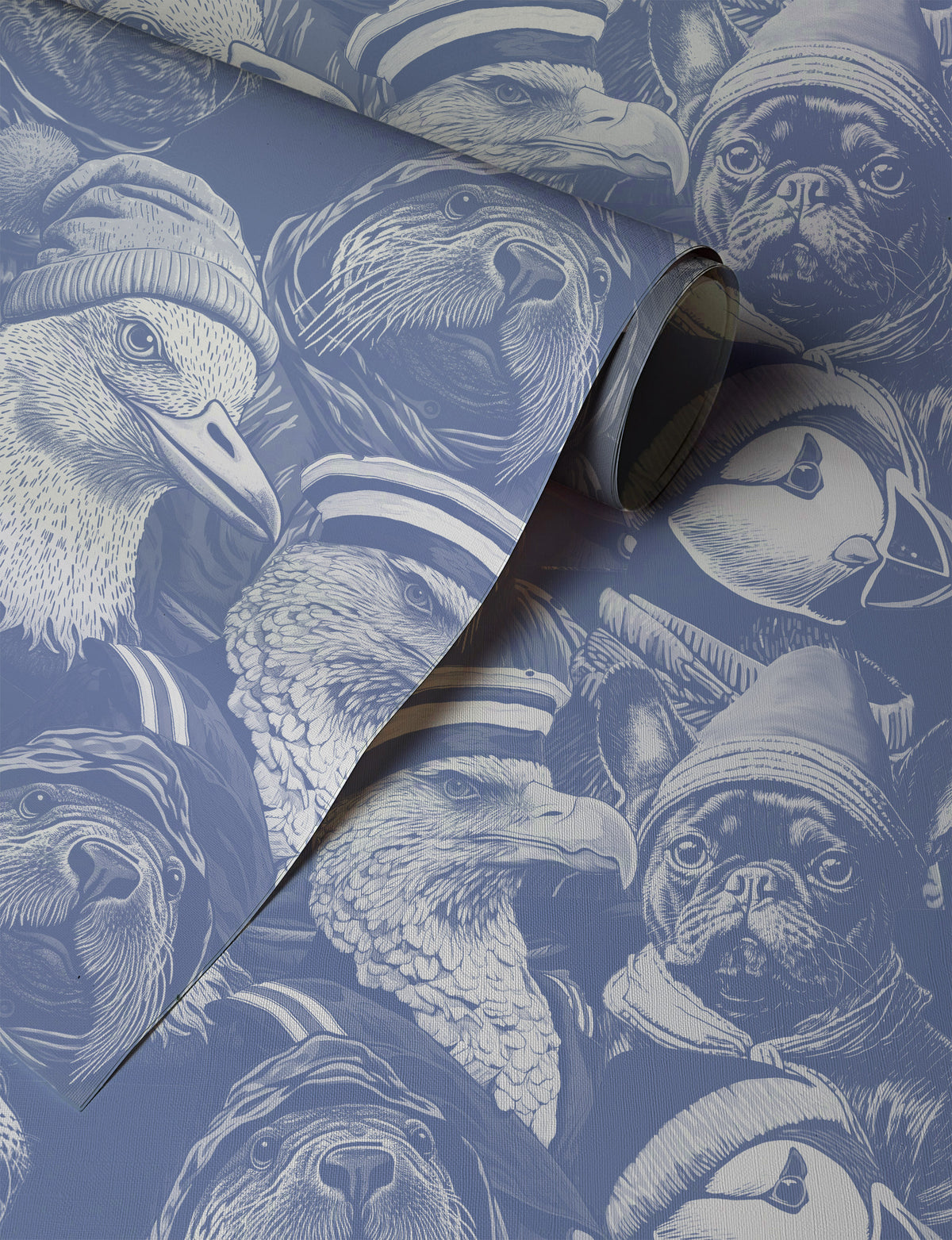 Blue peel-and-stick wallpaper sample featuring detailed illustrated animal portraits, including puffins, eagles, pugs, ducks, and sea otters wearing knit hats and sailor caps in a whimsical nautical style up close