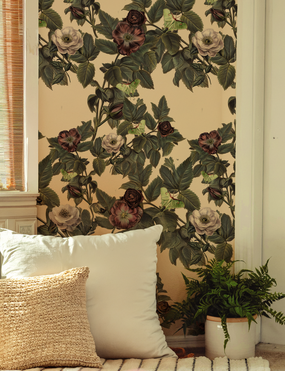 Luna Moth wallpaper with pale green moths, dusty mauve and cream roses, and deep green foliage on a warm ivory background on wall