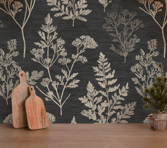 Wallpaper with botanical pattern on a dark background, wooden cutting boards and plant in the foreground.
