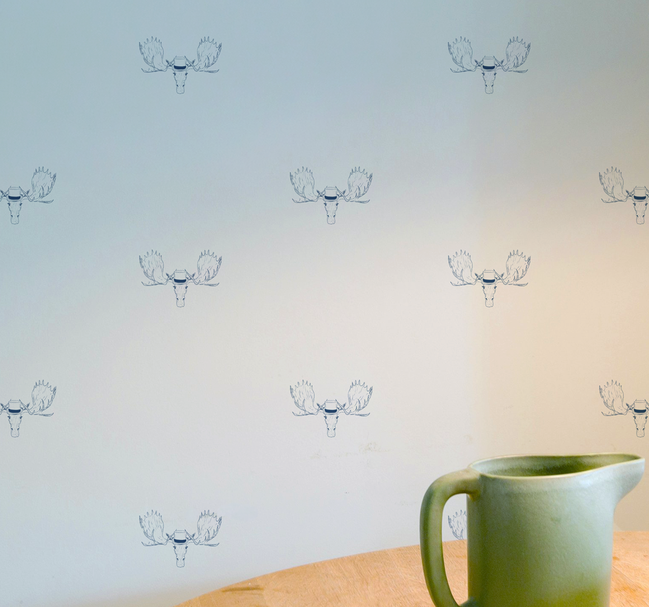 Minimal wallpaper with repeating moose head illustration wearing a top hat, subtle whimsical peel and stick wallpaper pattern on wall