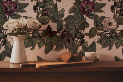 Vampire butterfly wallpaper with moody black and burgundy butterflies among vintage-style roses and green foliage on a soft blush background