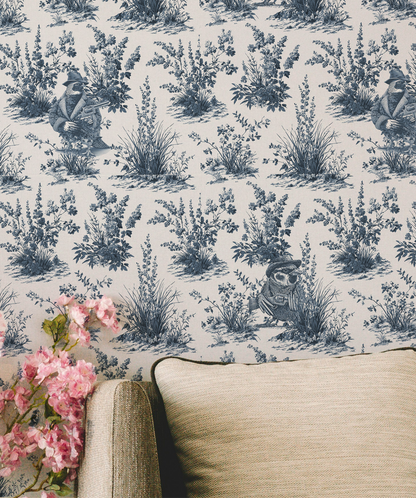Blue and white toile peel and stick wallpaper roll featuring vintage western wildlife birds and botanical illustrations, classic toile de jouy repeat pattern in blue ink on white background, in living room, removable wallpaper Canada