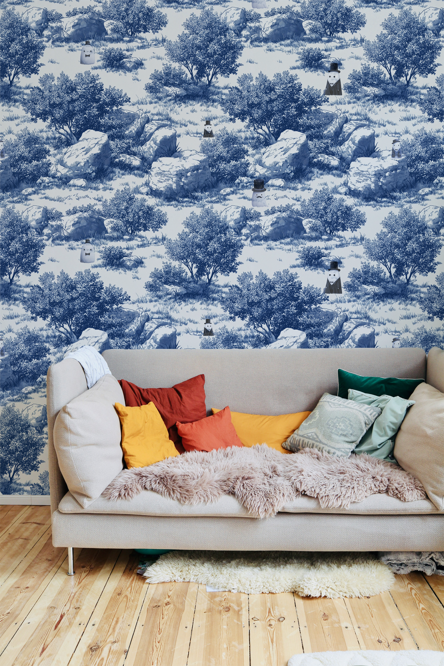 Blue toile peel and stick wallpaper with pastoral landscape, rocks and trees, whimsical ghost characters in vintage top hats in living room