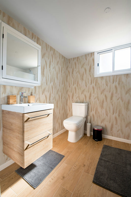 Neutral botanical wallpaper featuring soft pampas grass plumes and dried meadow grasses in warm ivory, cream, and sandy beige tones on a light background in bathroom