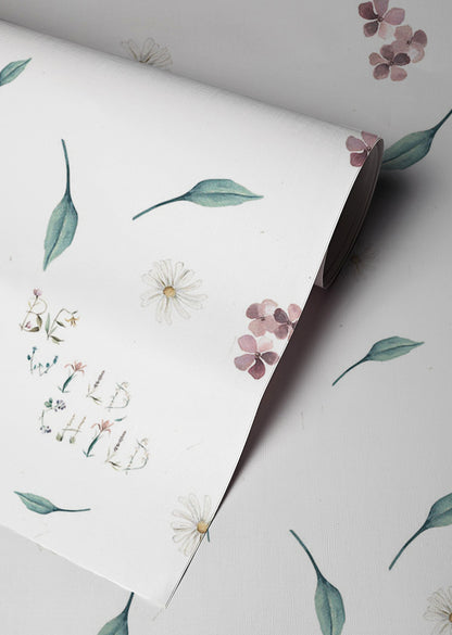 Soft floral nursery wallpaper with delicate wildflowers greenery and whimsical be wild child lettering on a neutral background in a cottagecore style