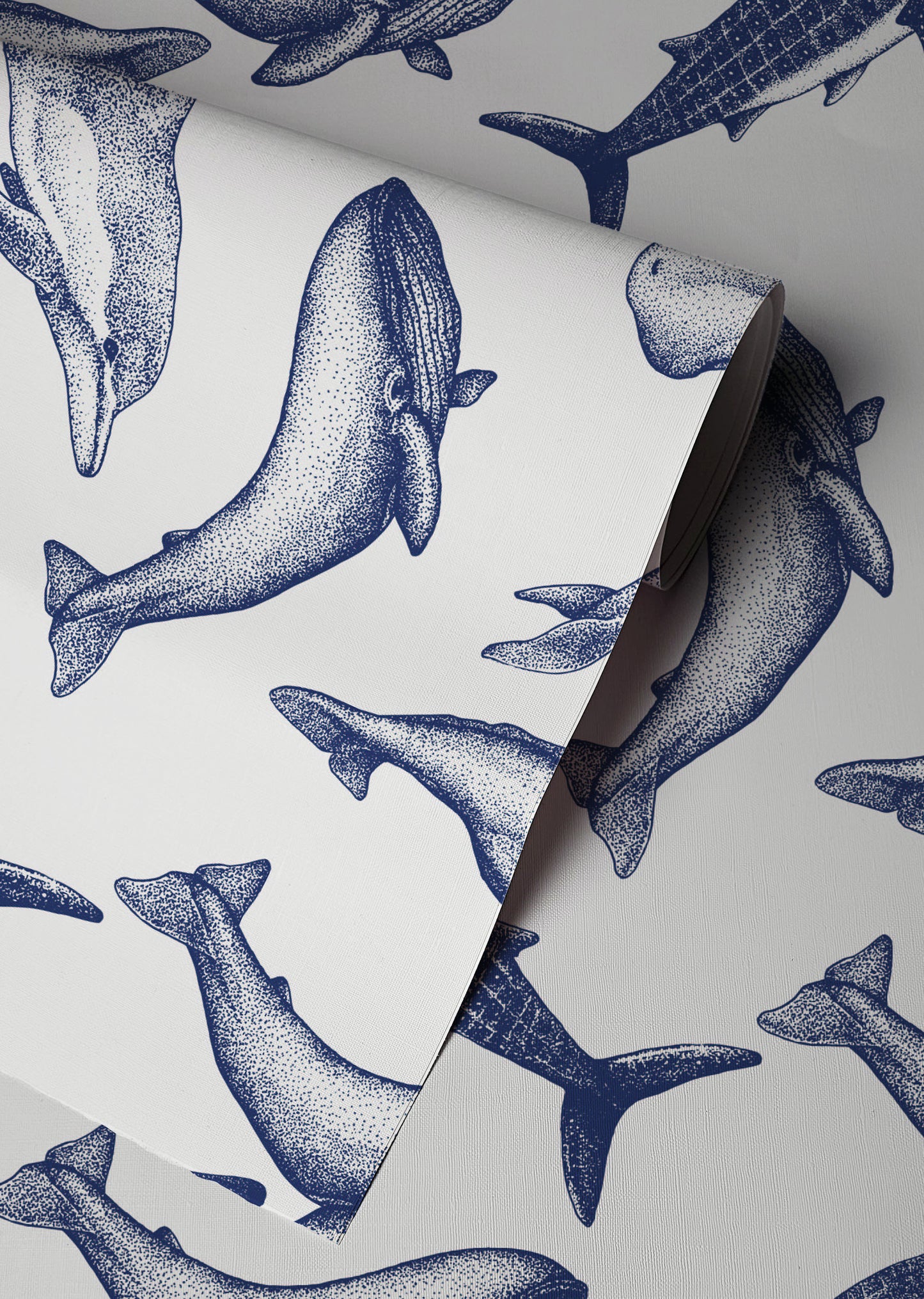 Coastal whale wallpaper with navy blue vintage style whale illustrations on a soft neutral background in a nautical cottage style interior