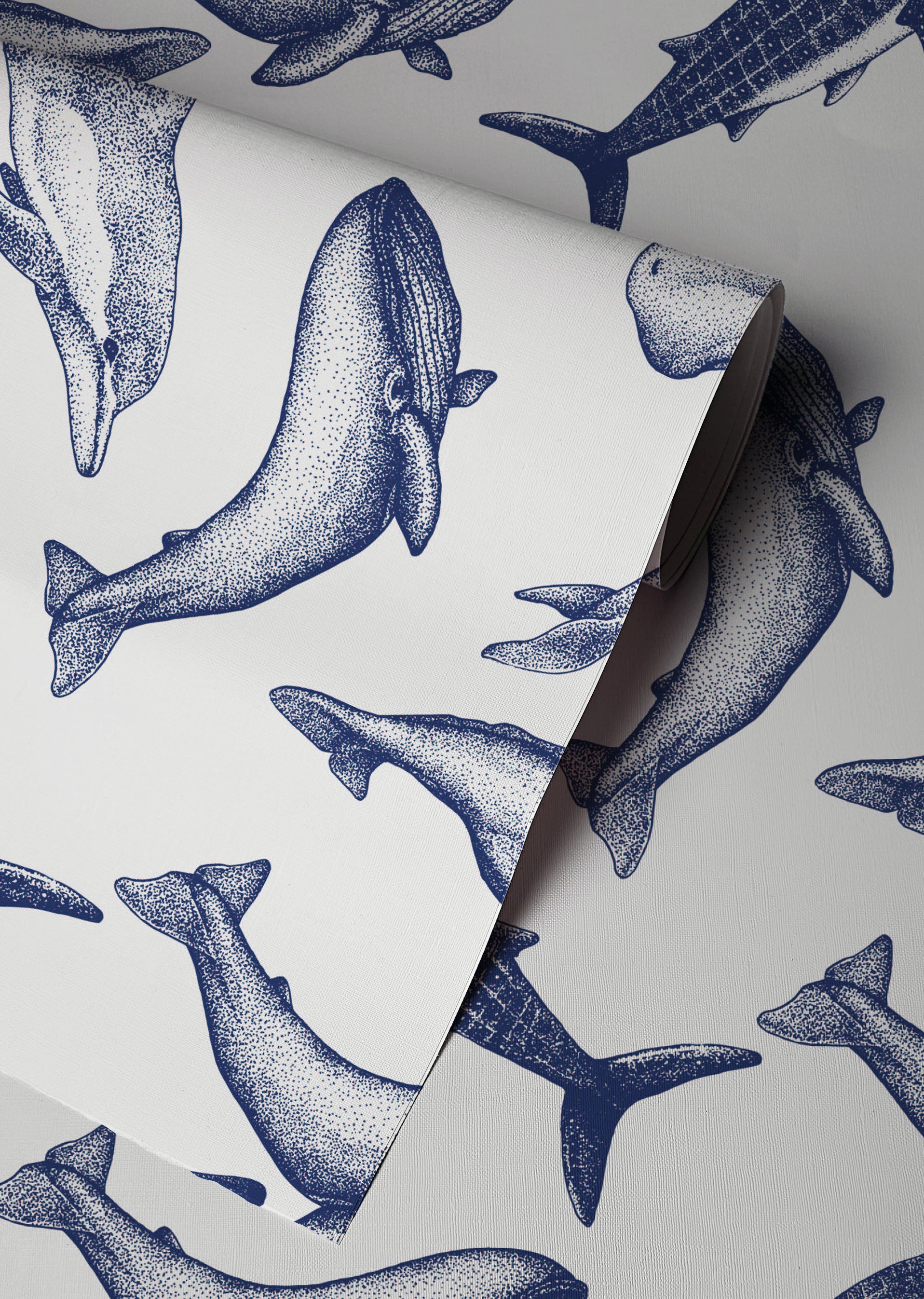 Coastal whale wallpaper with navy blue vintage style whale illustrations on a soft neutral background in a nautical cottage style interior