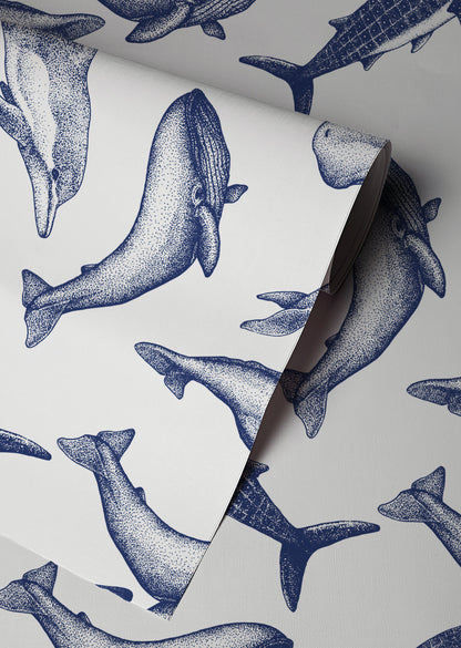 Coastal whale wallpaper with navy blue vintage style whale illustrations on a soft neutral background in a nautical cottage style interior