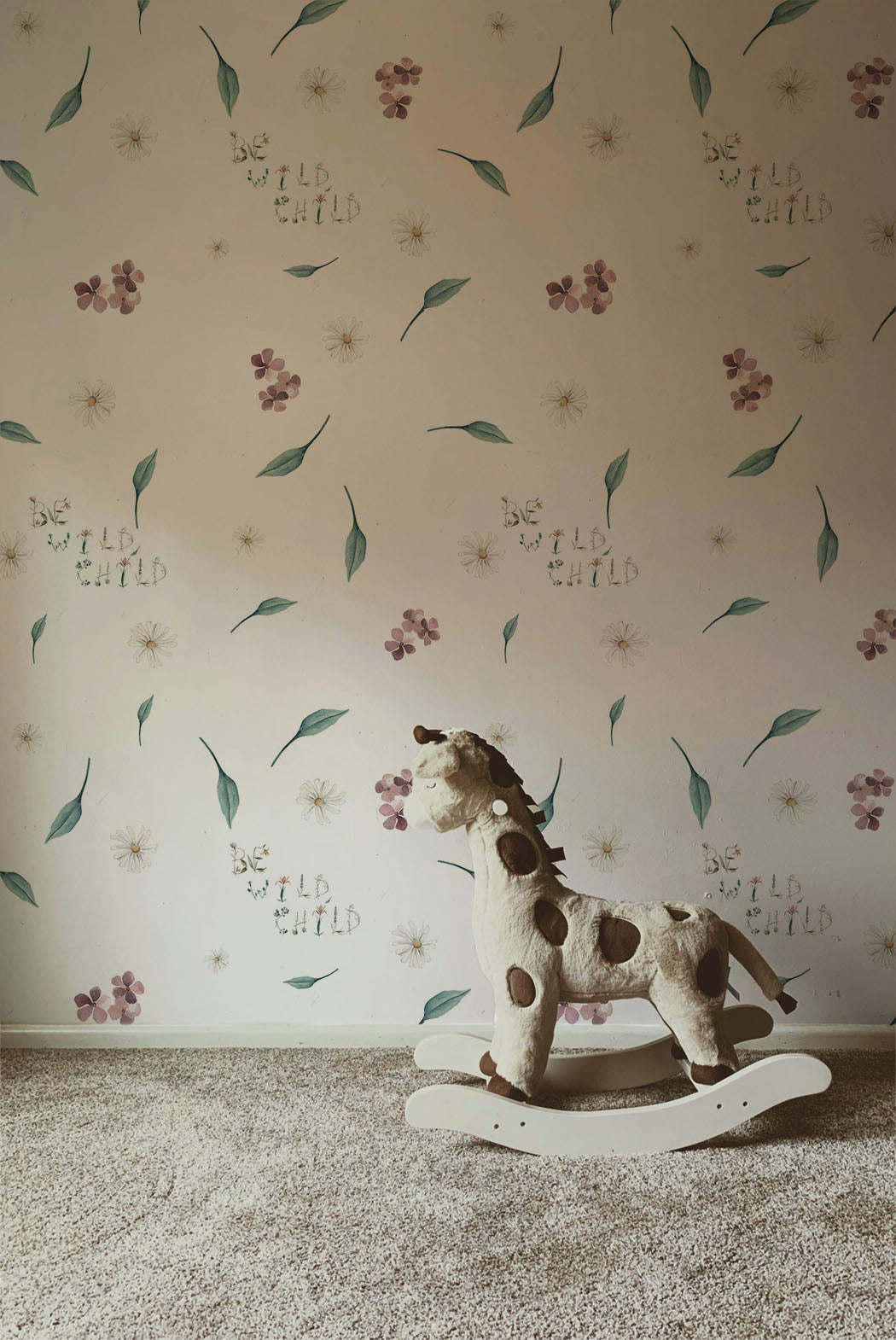 Soft floral nursery wallpaper with delicate wildflowers greenery and whimsical be wild child lettering on a neutral background in a cottagecore style