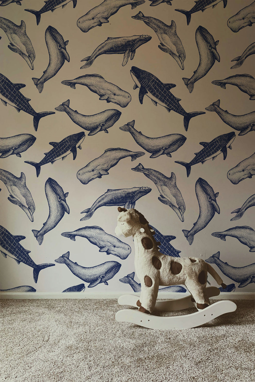 Coastal whale wallpaper with navy blue vintage style whale illustrations on a soft neutral background in a nautical cottage style interior