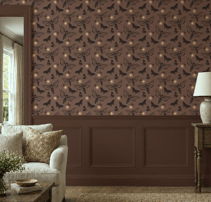 Dark cottagecore wallpaper featuring vintage death's head moths, butterflies, and glowing fireflies on a warm taupe background with peel and stick installation in living room 