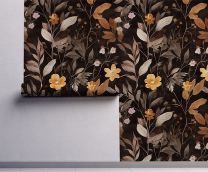 Dark botanical wallpaper featuring golden wildflowers, taupe foliage, and delicate floral stems on a black background, creating a moody cottagecore and dark academia aesthetic, on wall