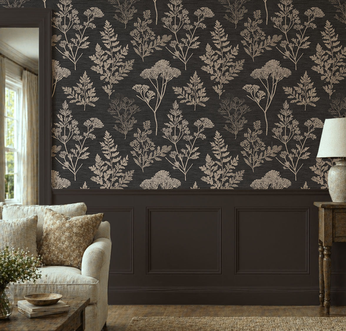 Dark botanical wallpaper featuring vintage herbarium silhouettes, delicate wildflowers, and fern fronds in warm beige on a charcoal black background, creating a moody cottagecore and dark academia aesthetic, in living room