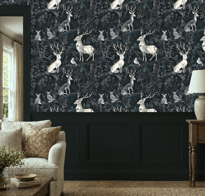 Dark woodland wallpaper featuring graceful deer, owls, and birds among twisting forest branches and soft botanical details on a deep moody background on wall