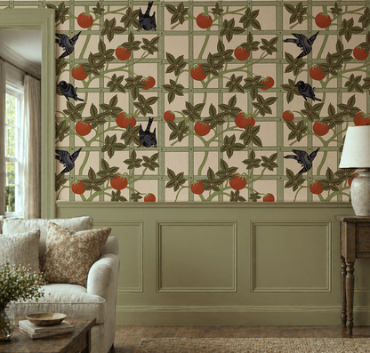 Vintage botanical wallpaper featuring black birds, red tomatoes and climbing green vines on a cream garden trellis in living room.