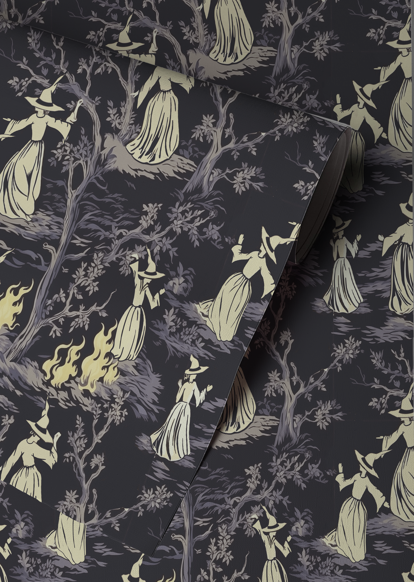 Moody peel-and-stick wallpaper sample featuring a witchy toile pattern with cream-cloaked figures, twisted gray trees, and glowing bonfire details on a deep charcoal background up close