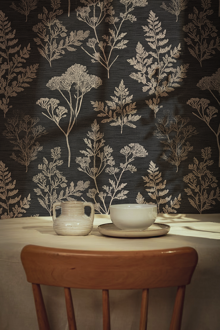 Dining table with ceramic cup and saucer against a dark botanical floral wallpaper.