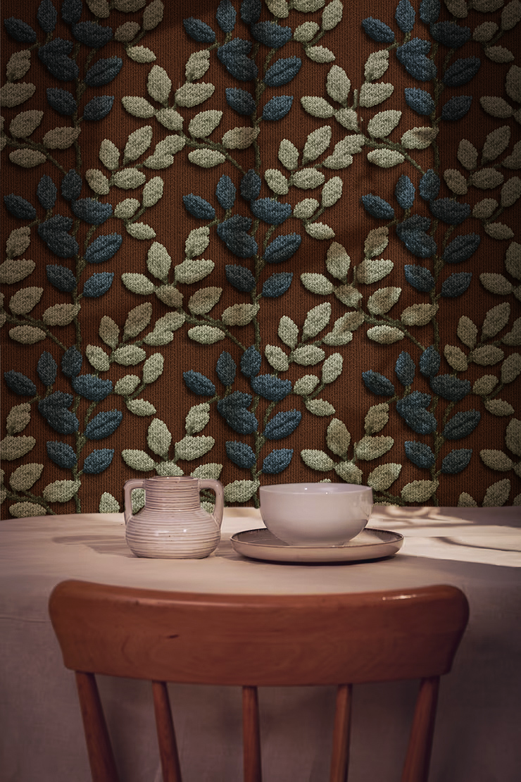 Textured botanical leaf wallpaper with blue and sage leaves on a warm rust background On wall