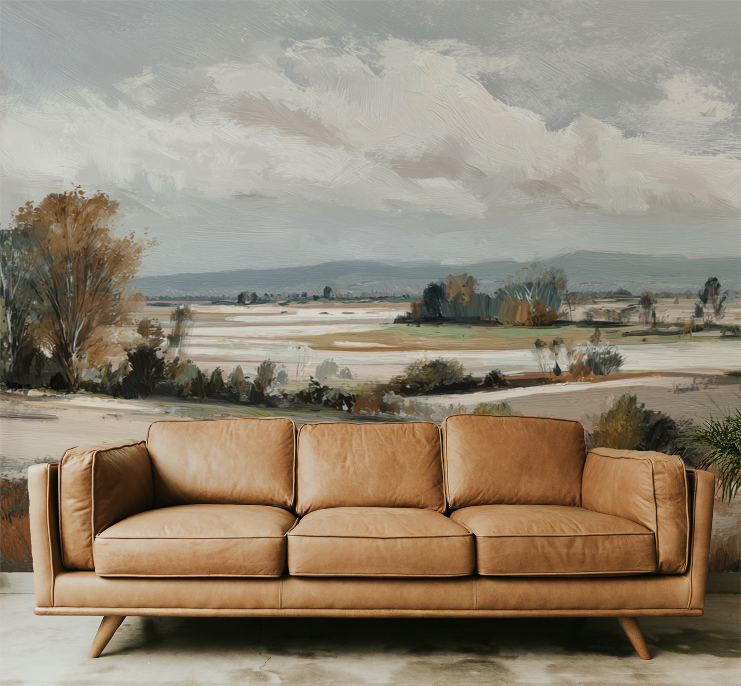 Brown leather sofa in front of a landscape wall mural