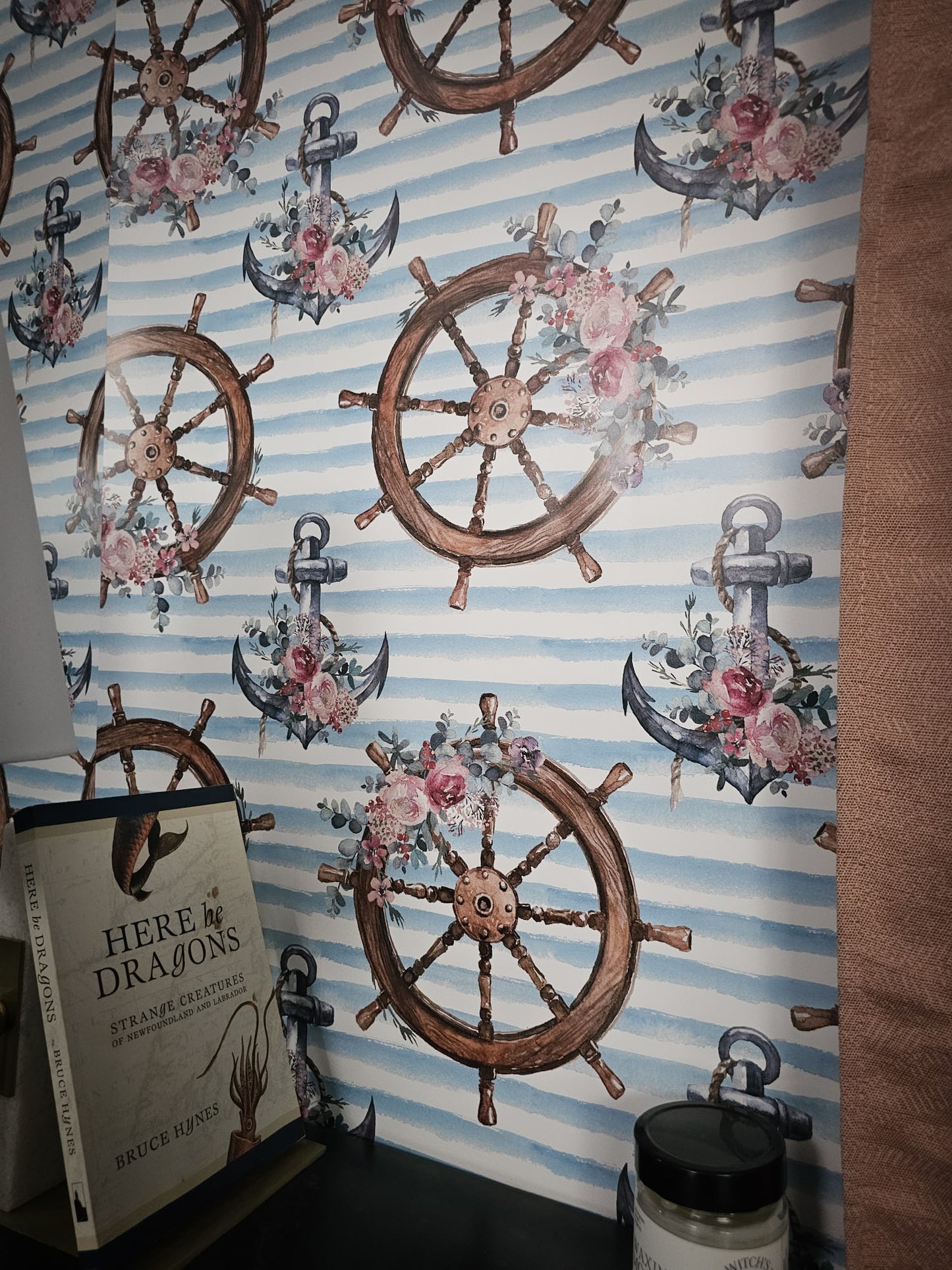 Wallpaper with nautical designs including ship wheels, anchors, and flowers on a striped background.