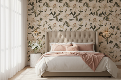 White lily floral wallpaper with large cream lilies, deep green leaves and subtle gold accents on a warm white background in bedroom.